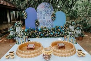 Home Outdoor wedding ceremony setup with blue mosaic backdrop and floral decorations"